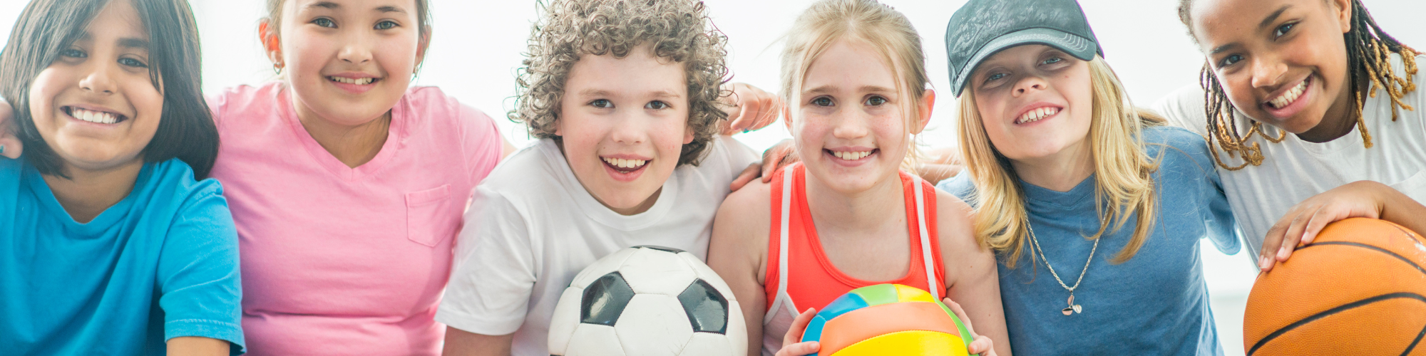 children with a soccer ball, volleyball and basketball
