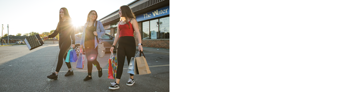 3 shoppers with bags in a parking lot